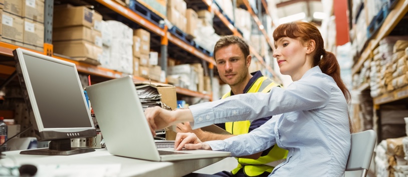 Logistics Manager sitting with colleague in warehouse