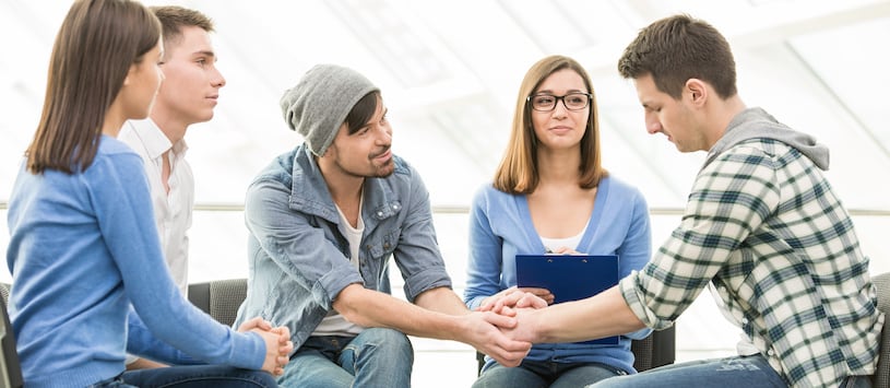 A counsellor comforting someone in a group therapy session.