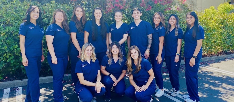 A group shot of SUI students wearing blue scrubs